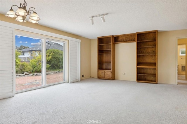 2132 El Dorado St, Los Osos, CA 93402 - unfurnished bedroom featuring access to exterior, light colored carpet, a chandelier, a textured ceiling, and track lighting