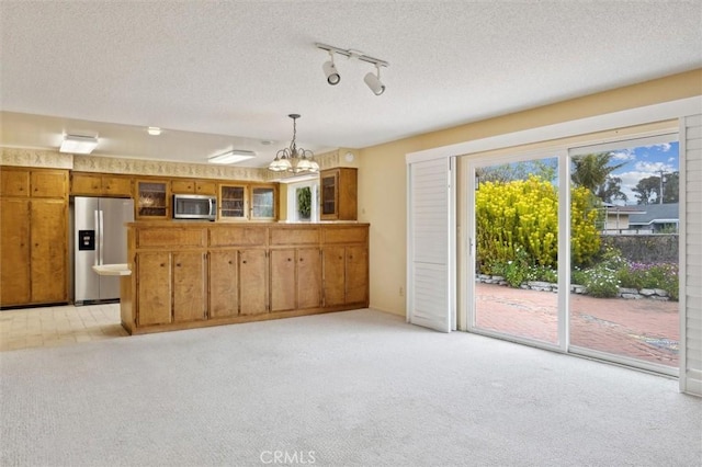 2132 El Dorado St, Los Osos, CA 93402 - kitchen with brown cabinetry, stainless steel appliances, a chandelier, and light carpet