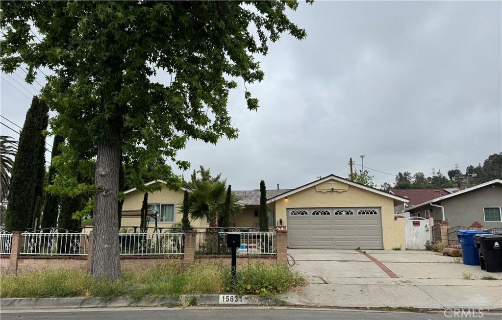 view of front of home featuring fence private yard, a garage, stucco siding, and driveway