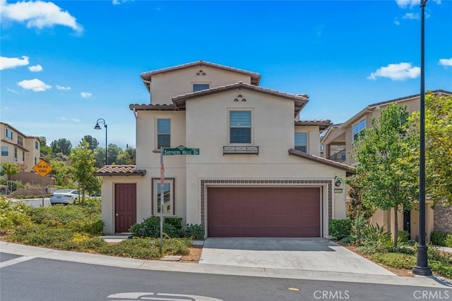 mediterranean / spanish house with a garage, stucco siding, driveway, and a tile roof