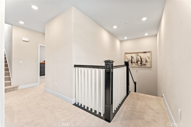 hall featuring baseboards, carpet flooring, recessed lighting, and an upstairs landing