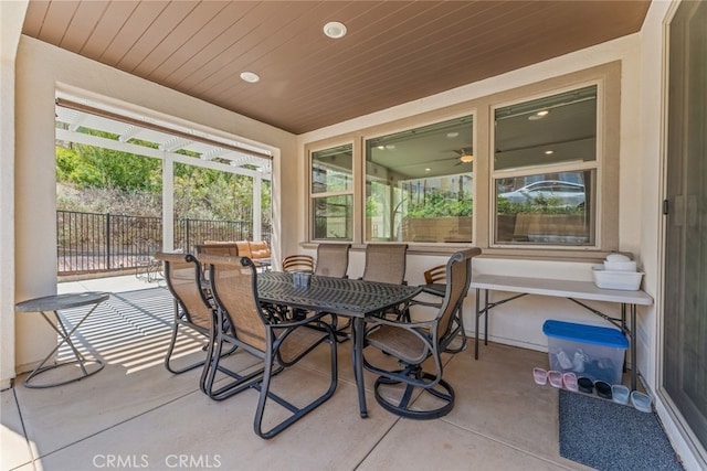 sunroom featuring recessed lighting, wooden ceiling, outdoor dining area, and concrete floors