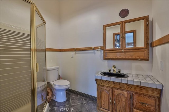 bathroom featuring tile patterned flooring, vanity, toilet, baseboards, and a shower stall