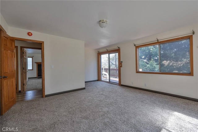 spare room with baseboards and carpet flooring