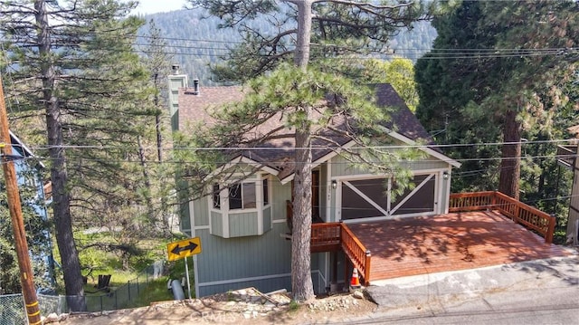 exterior space with fence, a chimney, and roof with shingles