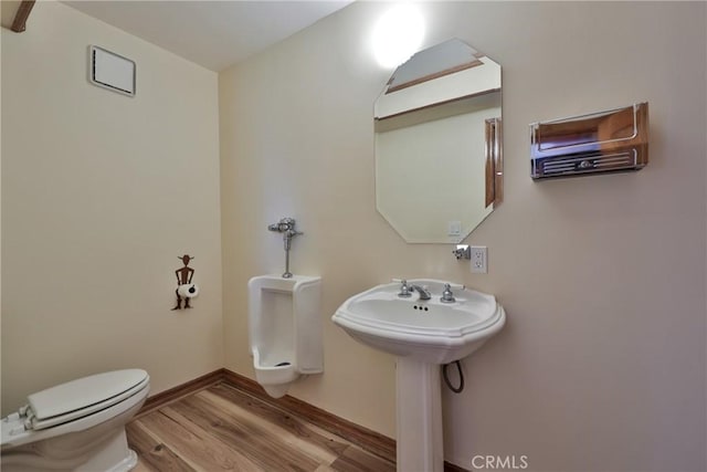 half bathroom featuring toilet, baseboards, and wood finished floors