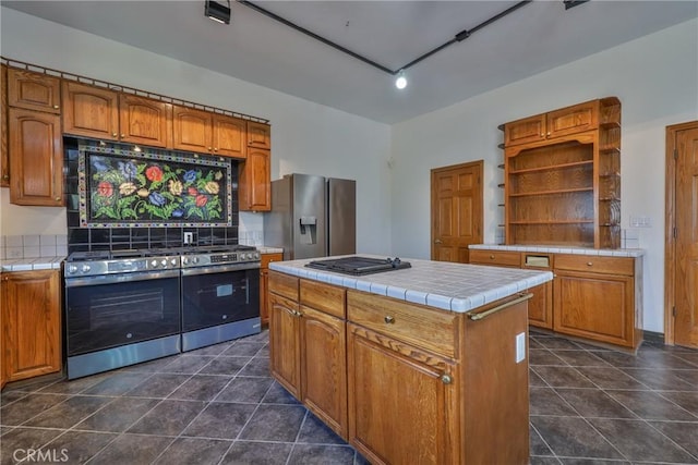 kitchen featuring a center island, tile countertops, open shelves, and stainless steel appliances