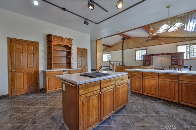 kitchen with tile countertops, open shelves, black gas stovetop, open floor plan, and vaulted ceiling with beams