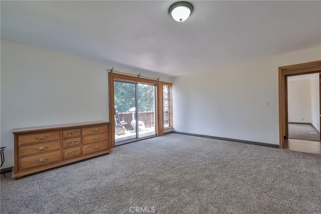unfurnished room featuring baseboards and carpet