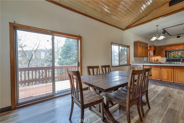 dining room featuring light wood-style floors, wooden ceiling, vaulted ceiling, and a notable chandelier