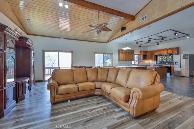 living room with ceiling fan, lofted ceiling with beams, rail lighting, and visible vents