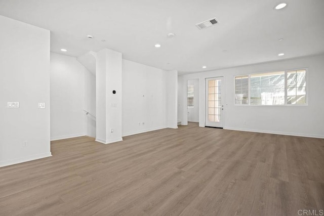 unfurnished living room with visible vents, recessed lighting, baseboards, and wood finished floors