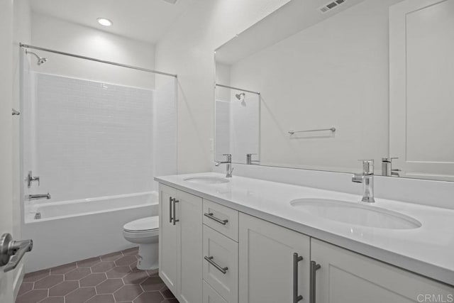 bathroom with double vanity, a sink, shower / bathing tub combination, and toilet