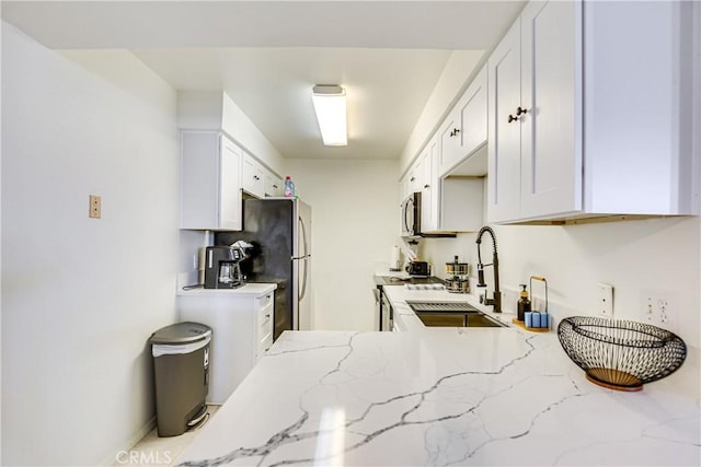 1100 E Amado Rd Unit 11A1, Palm Springs, CA 92262 - kitchen featuring appliances with stainless steel finishes, a sink, light stone countertops, and white cabinets