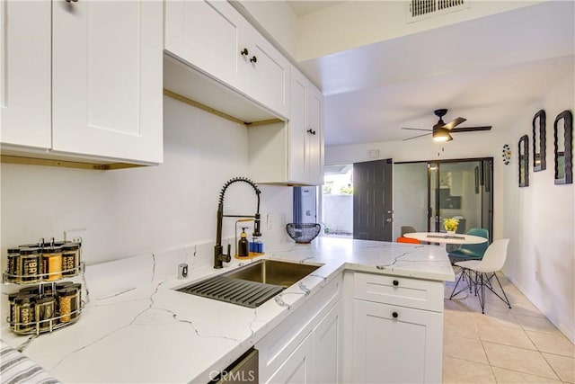 1100 E Amado Rd Unit 11A1, Palm Springs, CA 92262 - kitchen with a sink, white cabinets, a ceiling fan, and light stone countertops