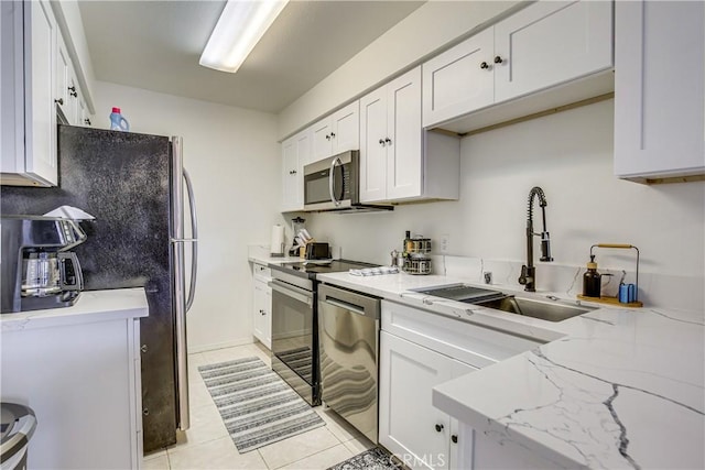 1100 E Amado Rd Unit 11A1, Palm Springs, CA 92262 - kitchen featuring appliances with stainless steel finishes, a sink, light tile patterned floors, white cabinets, and light stone countertops