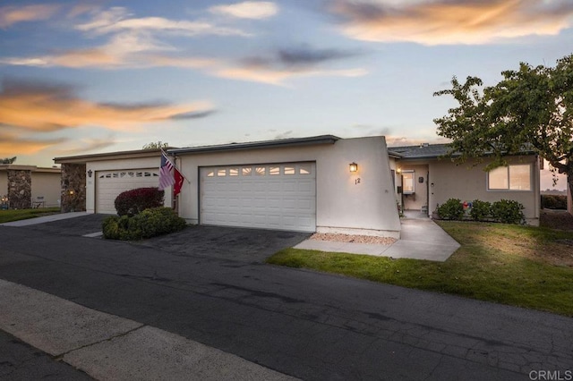 view of front of property with an attached garage, driveway, and stucco siding