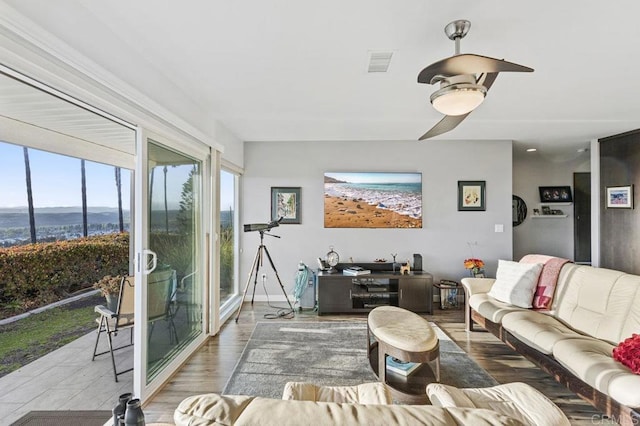 living room featuring visible vents, a ceiling fan, and wood finished floors