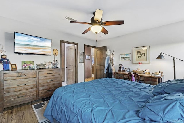 bedroom featuring visible vents, a ceiling fan, and wood finished floors