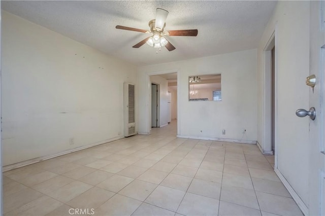 10180 Eddystone St, Riverside, CA 92503 - empty room with light tile patterned flooring, a heating unit, a textured ceiling, a ceiling fan, and baseboards