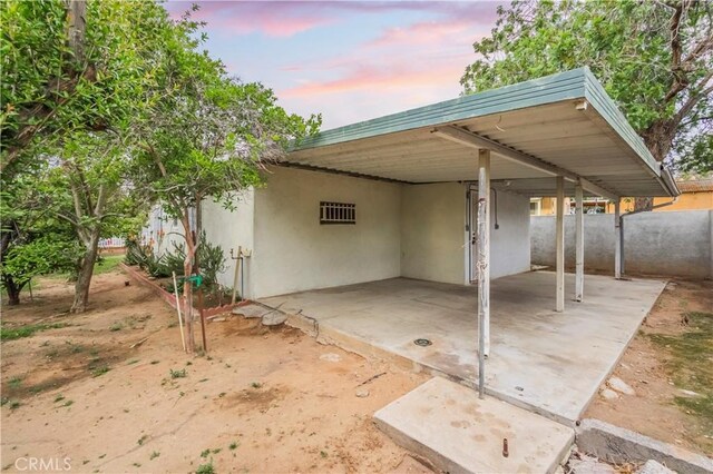 10180 Eddystone St, Riverside, CA 92503 - patio terrace at dusk with fence and a carport