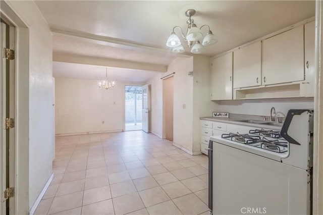 10180 Eddystone St, Riverside, CA 92503 - kitchen with a sink, baseboards, white range with gas cooktop, a notable chandelier, and white cabinetry