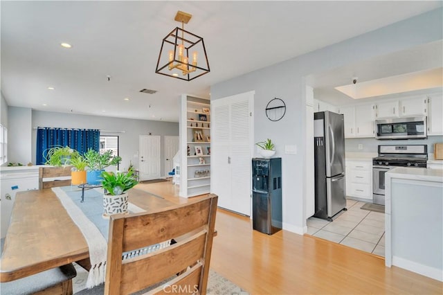 dining space with visible vents, baseboards, light wood finished floors, a chandelier, and recessed lighting