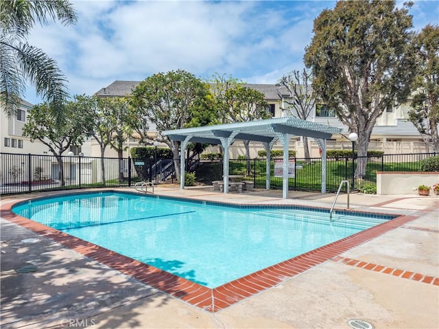 pool featuring a pergola, fence, and a patio area