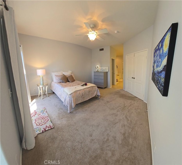 bedroom with visible vents, a ceiling fan, and light carpet