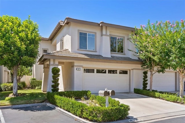 traditional-style home featuring an attached garage, concrete driveway, stucco siding, and a tile roof