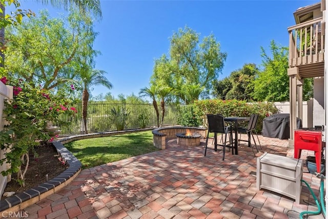 view of patio / terrace featuring a fire pit, outdoor dining space, a grill, and a fenced backyard