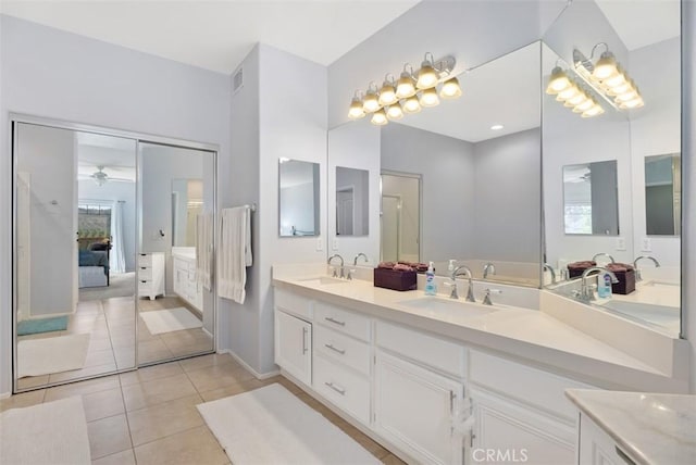 bathroom featuring tile patterned flooring, ensuite bath, double vanity, and a sink
