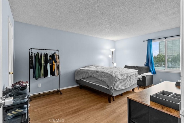 bedroom featuring light wood finished floors and a textured ceiling