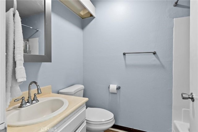 bathroom featuring vanity, walk in shower, and toilet