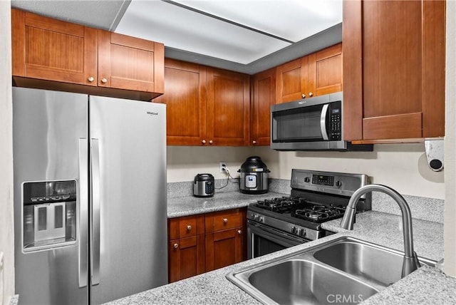 kitchen with a sink, brown cabinets, and stainless steel appliances
