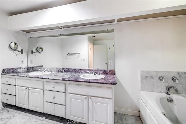 full bath featuring a sink, a bath, double vanity, and marble finish floor