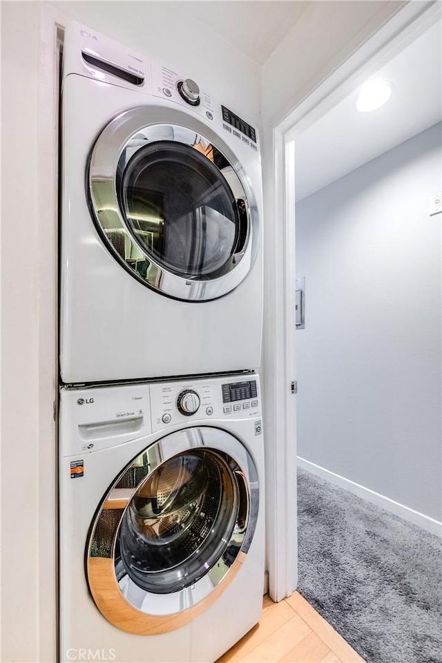 laundry room featuring stacked washer / drying machine and laundry area