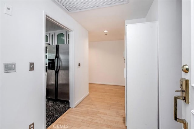 corridor featuring light wood-style floors, baseboards, recessed lighting, and visible vents