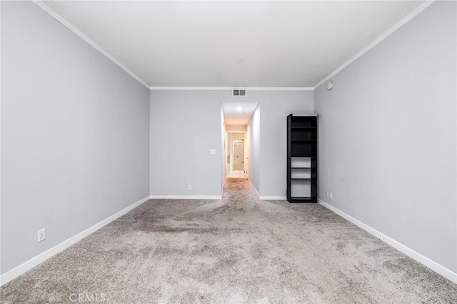 spare room with crown molding, baseboards, carpet, and visible vents