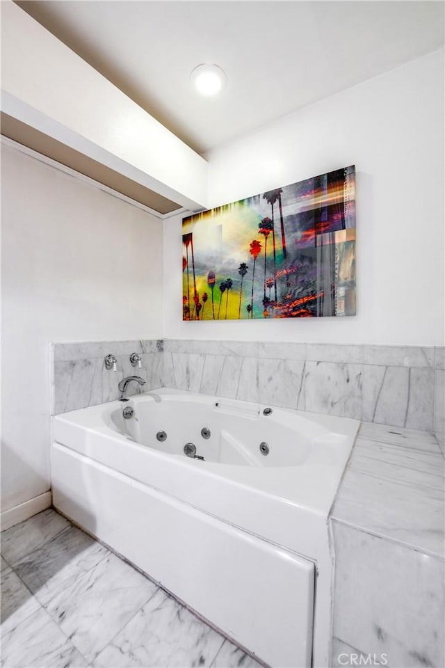 bathroom featuring a jetted tub and marble finish floor