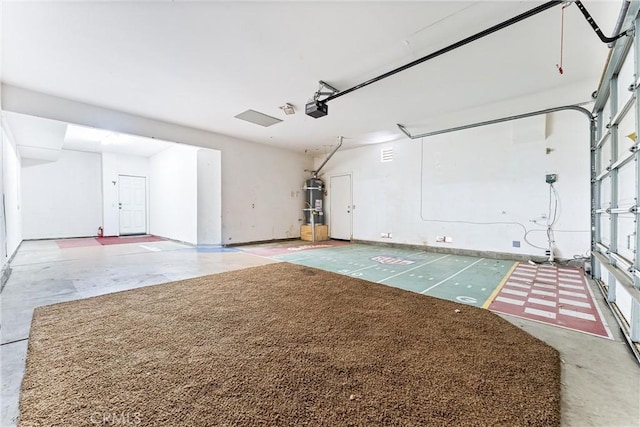 garage featuring strapped water heater and a garage door opener