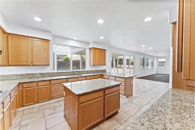 kitchen featuring a sink, recessed lighting, a peninsula, and light stone counters