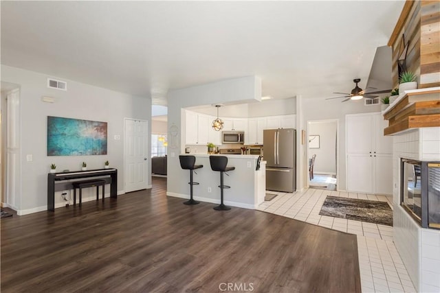 41787 Humber Dr, Temecula, CA 92591 - living room with a tile fireplace, a ceiling fan, light wood-style flooring, and baseboards