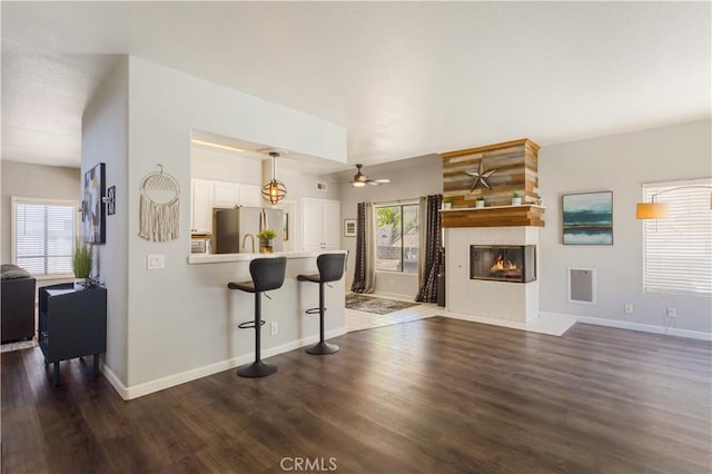 41787 Humber Dr, Temecula, CA 92591 - living area with healthy amount of natural light, dark wood-style flooring, a fireplace, and a ceiling fan