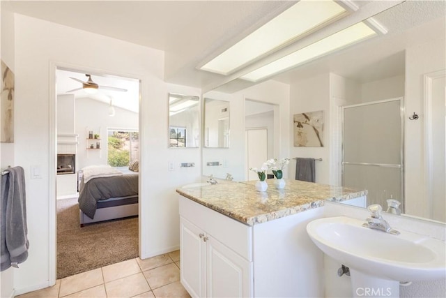 41787 Humber Dr, Temecula, CA 92591 - ensuite bathroom with a sink, a shower stall, a ceiling fan, tile patterned flooring, and a large fireplace