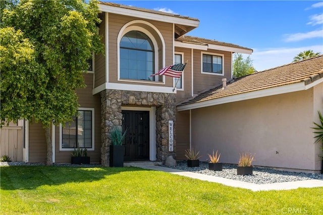 41787 Humber Dr, Temecula, CA 92591 - doorway to property with a lawn, stone siding, and stucco siding