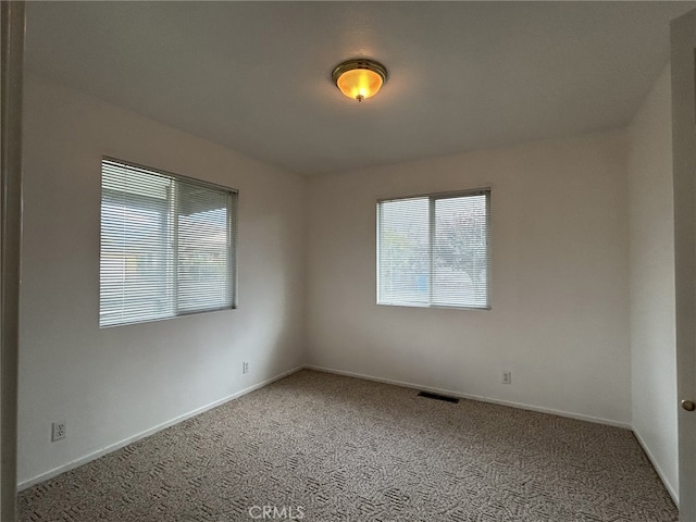 unfurnished room featuring baseboards, carpet, and visible vents