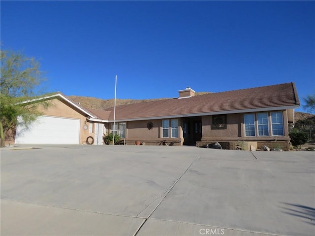 48628 Adeline Way, Morongo Valley, CA 92256 - single story home featuring a chimney, a garage, stucco siding, a tile roof, and concrete driveway