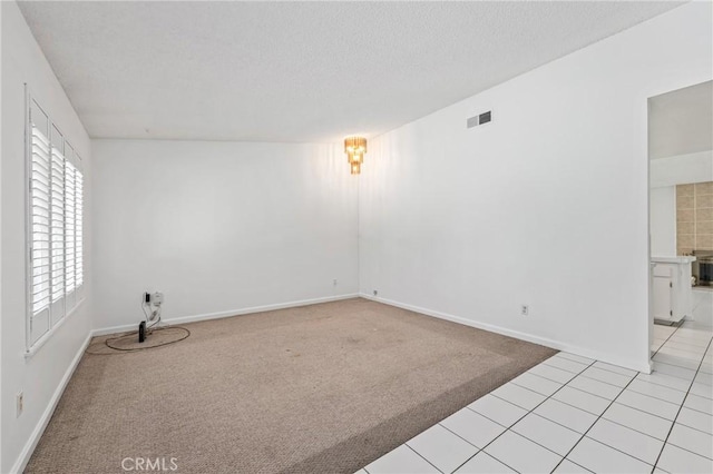 1620 S Cypress Ave, Ontario, CA 91762 - empty room featuring light colored carpet, a textured ceiling, and light tile patterned flooring
