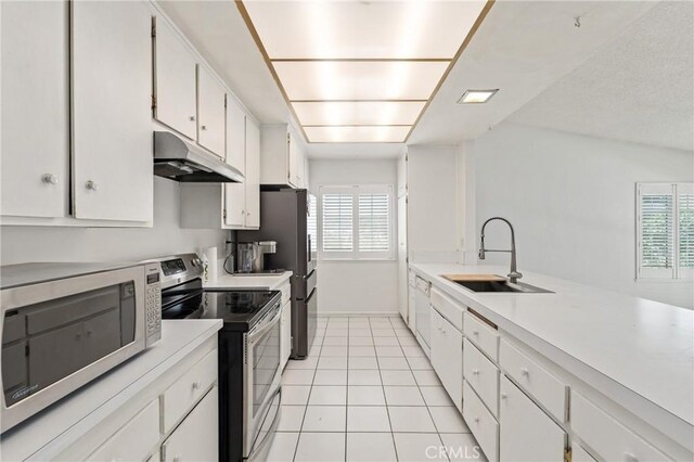 1620 S Cypress Ave, Ontario, CA 91762 - kitchen with under cabinet range hood, stainless steel appliances, healthy amount of natural light, and light tile patterned flooring